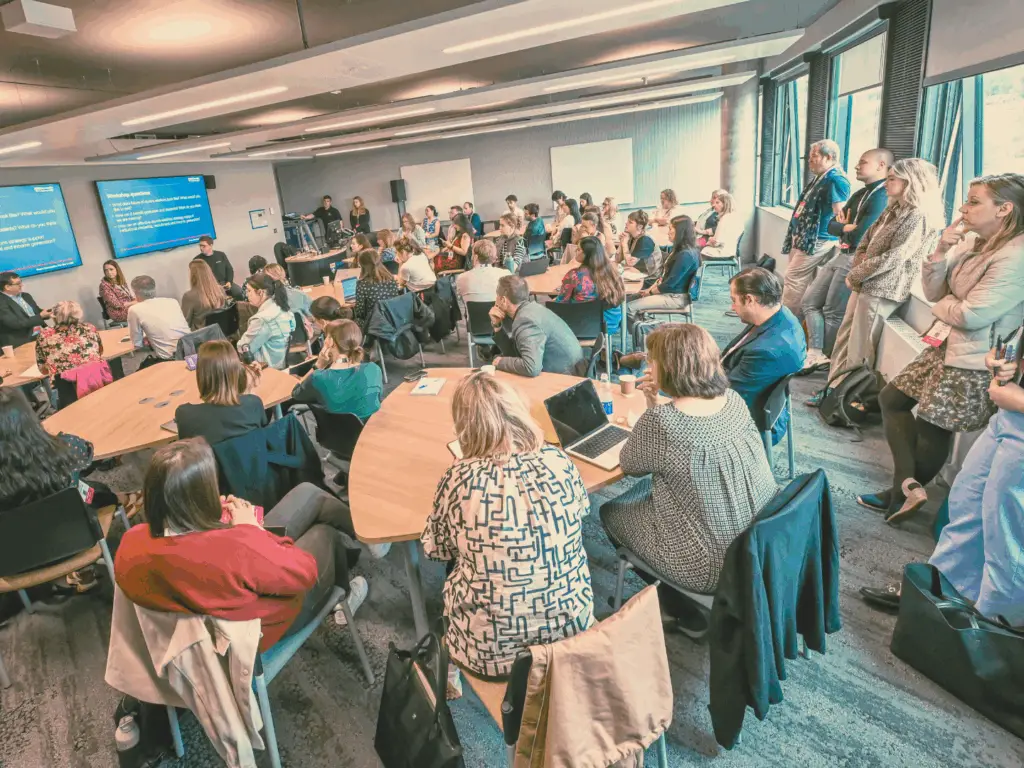 Full room of people all looking at the front screen.